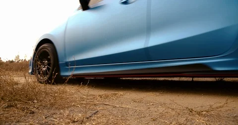 SLOW MOTION, Close up Hatchback car Driving on beautiful forest summer sunset Видео 124582393