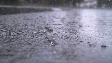 SLOW MOTION, CLOSE UP: Heavy rain water drops falling into puddle on the street Stock Footage 94500175