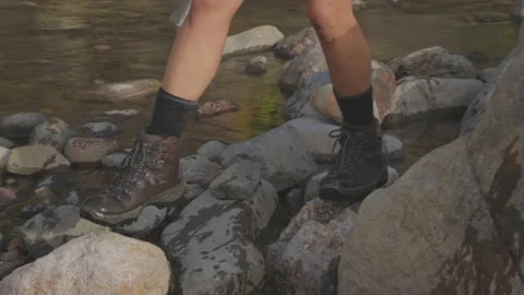Slow Motion Close up hiking through a rocky river Stock Footage 152426547