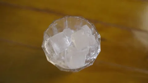 Slow motion close-up of ice cubes falling into a glass. Stock Footage 231053278