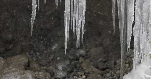 Slow motion close up of icicles melting, snow falling Stock Footage 148442165