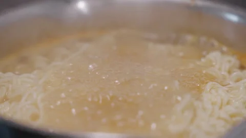 Slow motion, close up of instant noodles cooking in a pot Stock-Footage 332684498