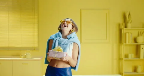 Slow motion close up of joyful trendy young woman in round sunglasses holding a Video stock 188103236
