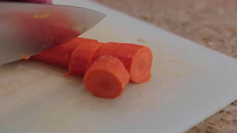 Slow motion close up of a knife slicing a carrot on a cutting board Stock-Footage 330306448