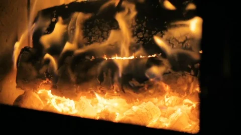 SLOW MOTION: close-up a large wood logs burn slowly in the fireplace. Video stock 83545501