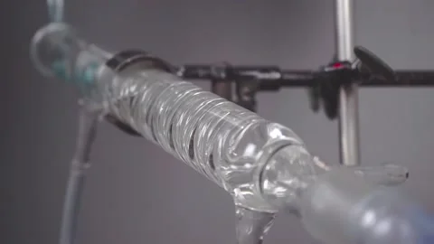 Slow motion close up of liquid running through apparatus  in chemistry lab Stock Footage 133254096