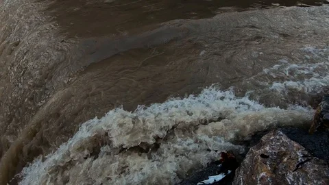 Slow motion close up looking down on dirty brown flooded river water Stock Footage 120528315