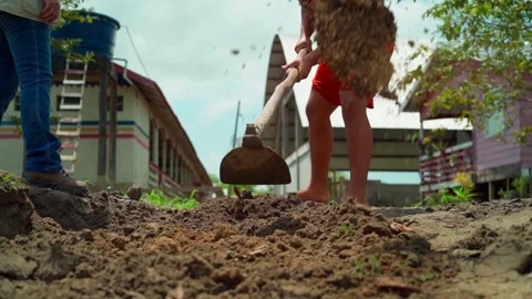 Slow-motion close-up of a man digging soil in an Amazon rainforest village Stock Footage 302354780
