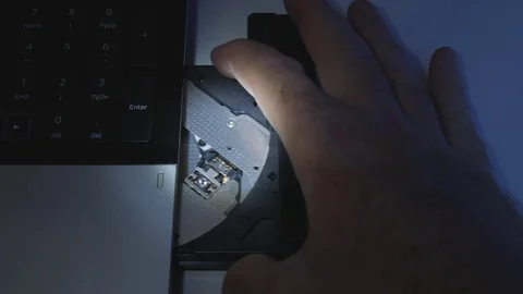 Slow Motion Close Up Man with a Flashlight Insert Cd in Laptop Cd Rom Vídeo Stock 80747039