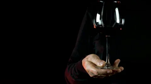 Slow motion. Close-up man's hand holding the red wine glass.  Vídeos de archivo 136955350