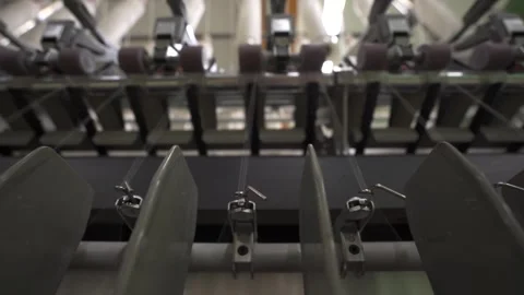 Slow motion close up of multiple threads passing through a spinning mill machine Stock Footage 257762032