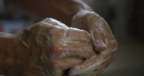 Slow motion close up on a pair of white hands thoroughly scrubbing with soap Stock Footage 64034336