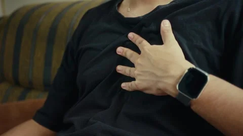 Slow motion close-up of person pressing chest with one hand Stock Footage 324859398