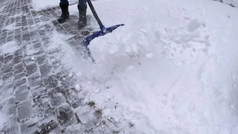 Slow-motion close-up of a person pushing a blue snow shovel, sending powder 스톡 동영상 328872307