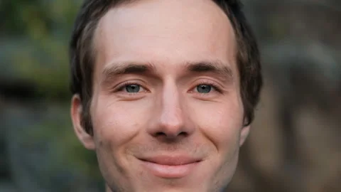Slow motion close-up portrait of a young attractive man smiling. Video stock 147400890