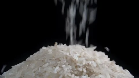 Slow motion close up of pouring rice isolated black background Stock Footage 277675475
