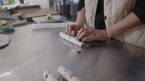 Slow motion close up of a professional baker hands skillfully rolling dough Stock Footage 328983546