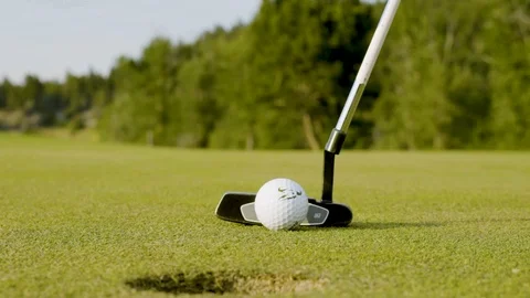 Slow motion close up of a putter striking a golf ball and sinking a short putt Stockbeeldmateriaal 133577906