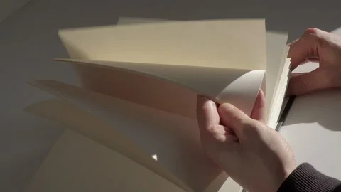 Slow motion close-up of quickly flipping through the white pages of the diary Stock Footage 229896600