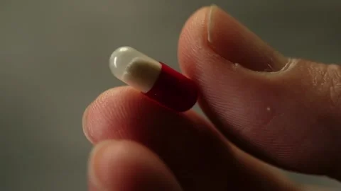 Slow Motion Close Up of Red White Antiviral Pill in Hand Stock Footage 327400666