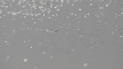 Slow motion close-up of reflection of the sun in sand after wave pulls back Stock Footage 169652465