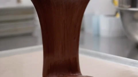 Slow Motion Close-up of Rich Chocolate Ganache Pouring onto a Dessert Pie Stock Footage 337751612