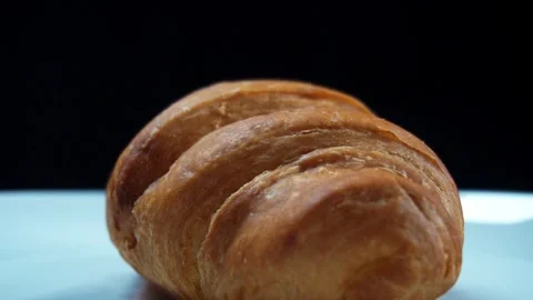 Slow motion close up of rotating croissant with flour dusting effect Stock Footage 278200116