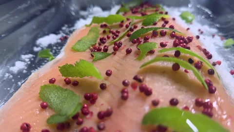Slow Motion Close-Up of Salmon Being Marinated with Lime Zest, Pink Peppercorns  Stock Footage 306883481