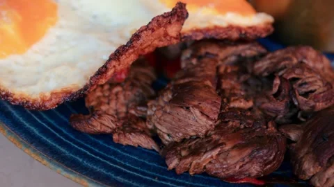 Slow motion close up of seared beef steak slices served with crispy fried e.. Stock Footage 339208521