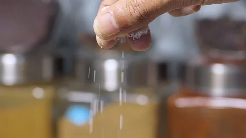 Slow motion close shot of chef's fingers holding and sprinkling a pinch of salt Stock Footage 149903678