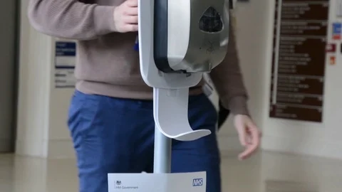 Slow motion, close shot of hands taking gel sanitizer from dispenser Stock Footage 126299178