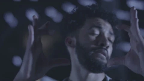 Slow motion close up shot of islamic guy dancing and smiling in dark room Stock Footage 211869328