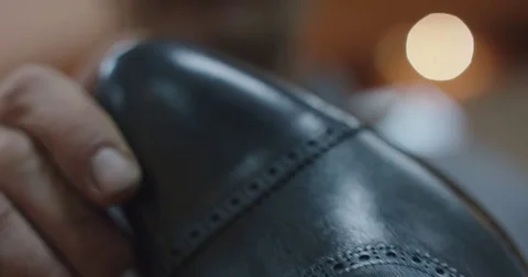Slow motion close up shot of man looking at a new made shoe. Stock Footage 71974028