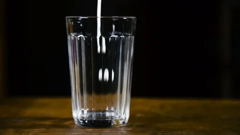 Slow Motion close-up Shot of Pouring Milk into Glass Stock Footage 108257883