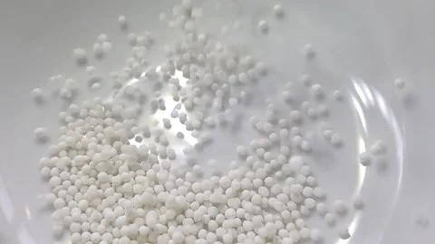 Slow motion close-up shot of pouring sago grain into a white ceramic bowl. Video stock 159442374
