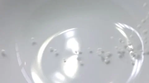 Slow motion close-up shot of pouring sago grain into a white ceramic bowl. Video stock 159442433