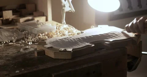Slow motion close up shot of violinmaker concentrating on carving, smoothing, Stock Footage 301827184