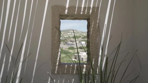 Slow motion close up shot of window looking at a village, focus on the wall Stock Footage 257950605