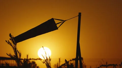 Slow motion close up silhouette of wind sock at amazing orange sunset among Stock Footage 245567528