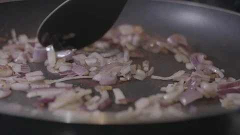 Slow Motion Close Up of Sliced Red Onions Frying in a Pan Stock Footage 128994420