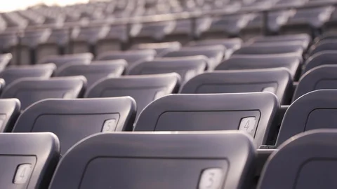 Slow motion close-up slider shot along aisle of empty seat numvers in football s Stock Footage 85758848