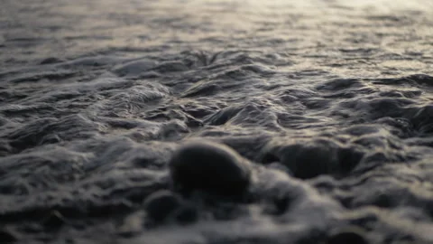Slow motion close up of small waves crashing against rocks at shore Stockbeeldmateriaal 277251695
