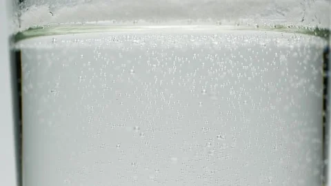 Slow motion close-up small white air bubbles in glass of water, soda drink Stock Footage 144591097