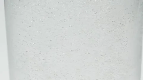 Slow motion close-up small white air bubbles in glass of water, soda drink Stock Footage 145785662