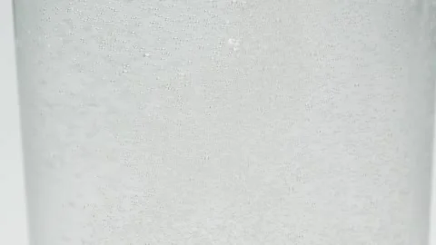 Slow motion close-up small white air bubbles in glass of water, soda drink Stock Footage 147238776