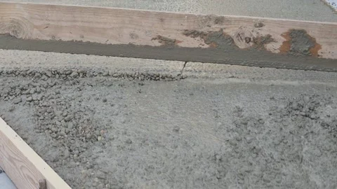 Slow motion close up of smoothing sloped concrete with wooden board Stock Footage 334802795