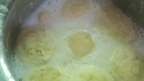 Slow motion close-up of soft Rasmalai dumplings in rich rabri Stock Footage 318653786