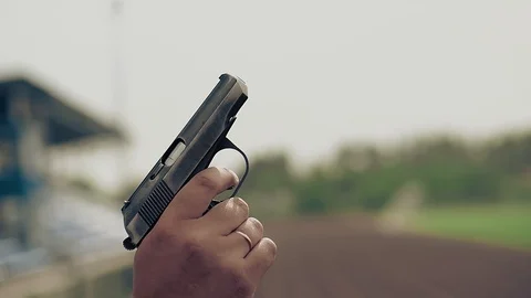 Slow motion close-up starting pistol gun in hand makes shot to start track and Stock Footage