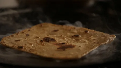 Slow motion close up of steaming hot roti in the making Stock Footage 128723313