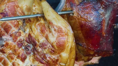 Slow motion close up of succulent ham roasting on rotisserie spit at outdoo.. 스톡 동영상 332636641